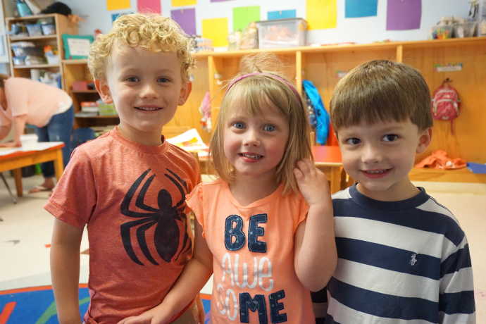 three kids in a classroom