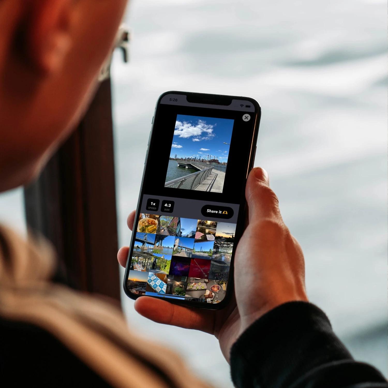 Man holding an iPhone showing the Happyfeed movie maker