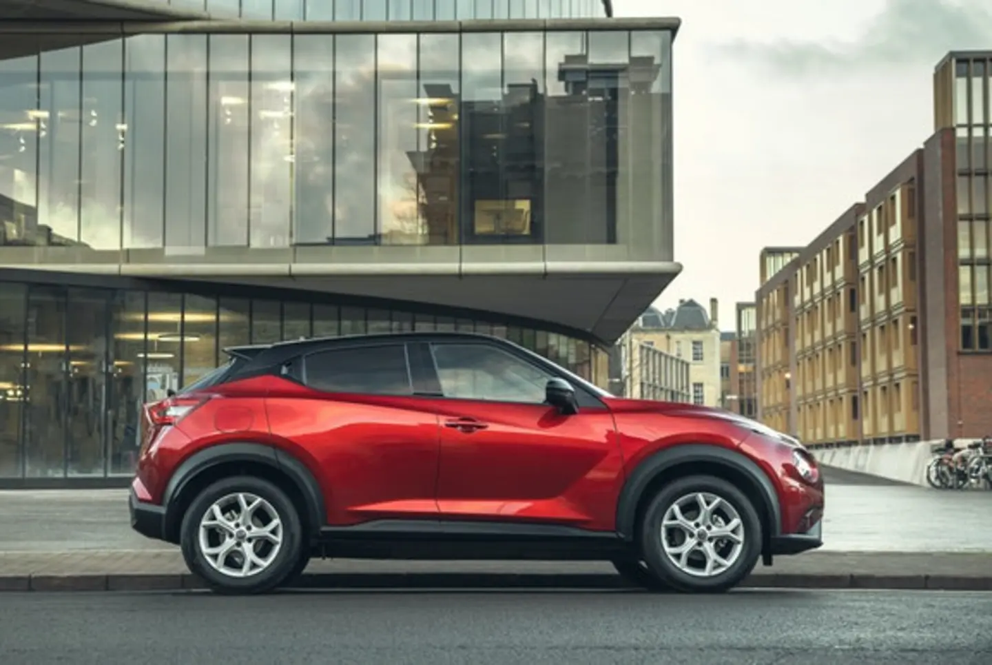 Red Nissan Juke parked in front of an office building