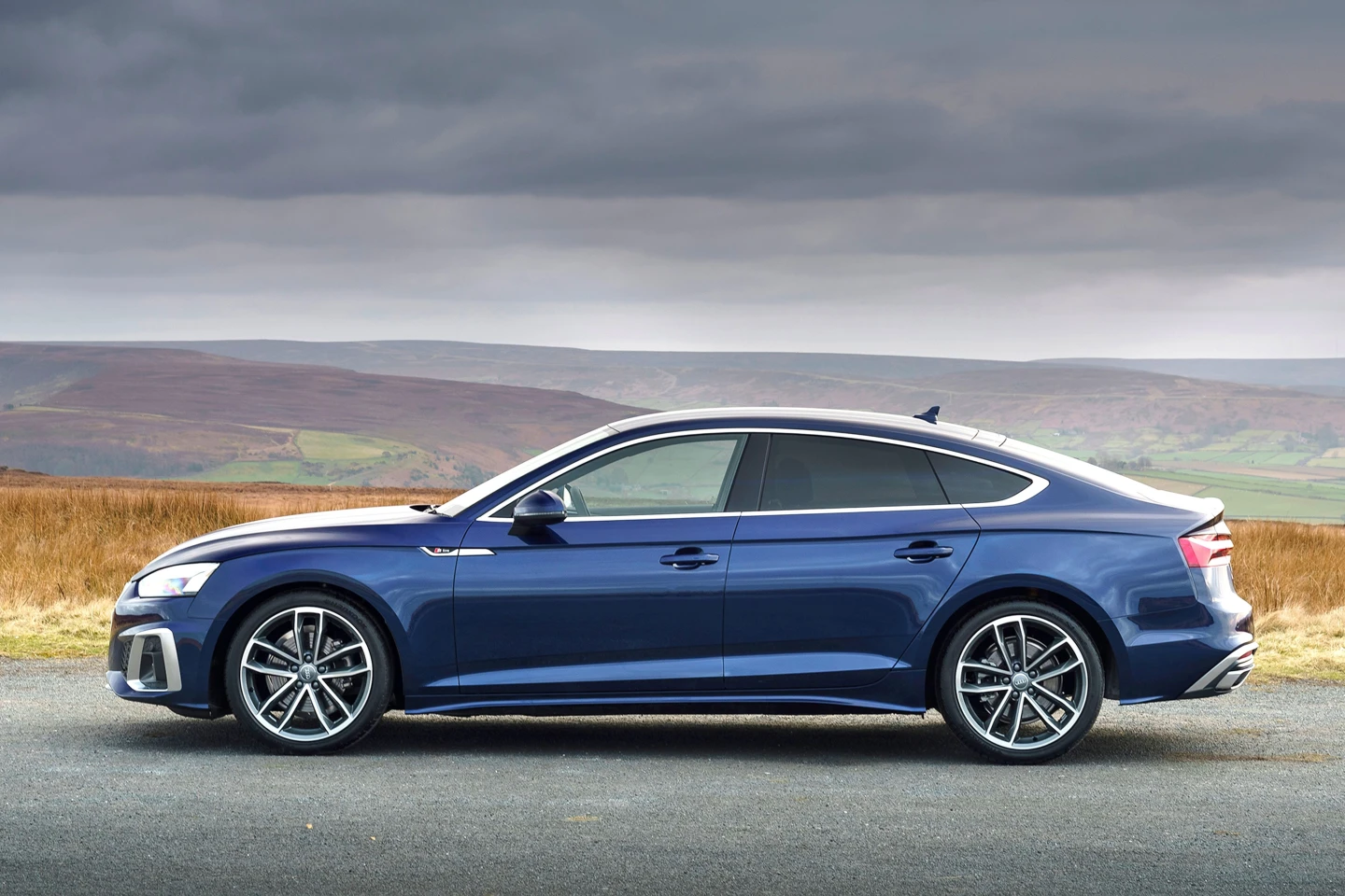Blue Audi A5 Sportback parked in a countryside setting