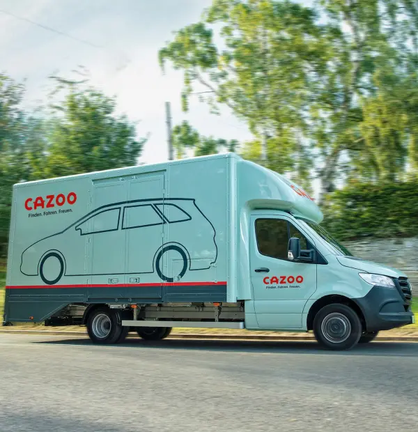 Cazoo liefert dein Auto kostenlos zu dir nach Hause. Lieferungen sind schon in 5 Werktagen möglich. Auf dem Bild zu sehen ist ein Cazoo Transporter.