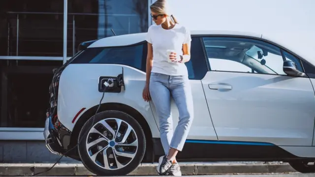 A woman charging her electric car