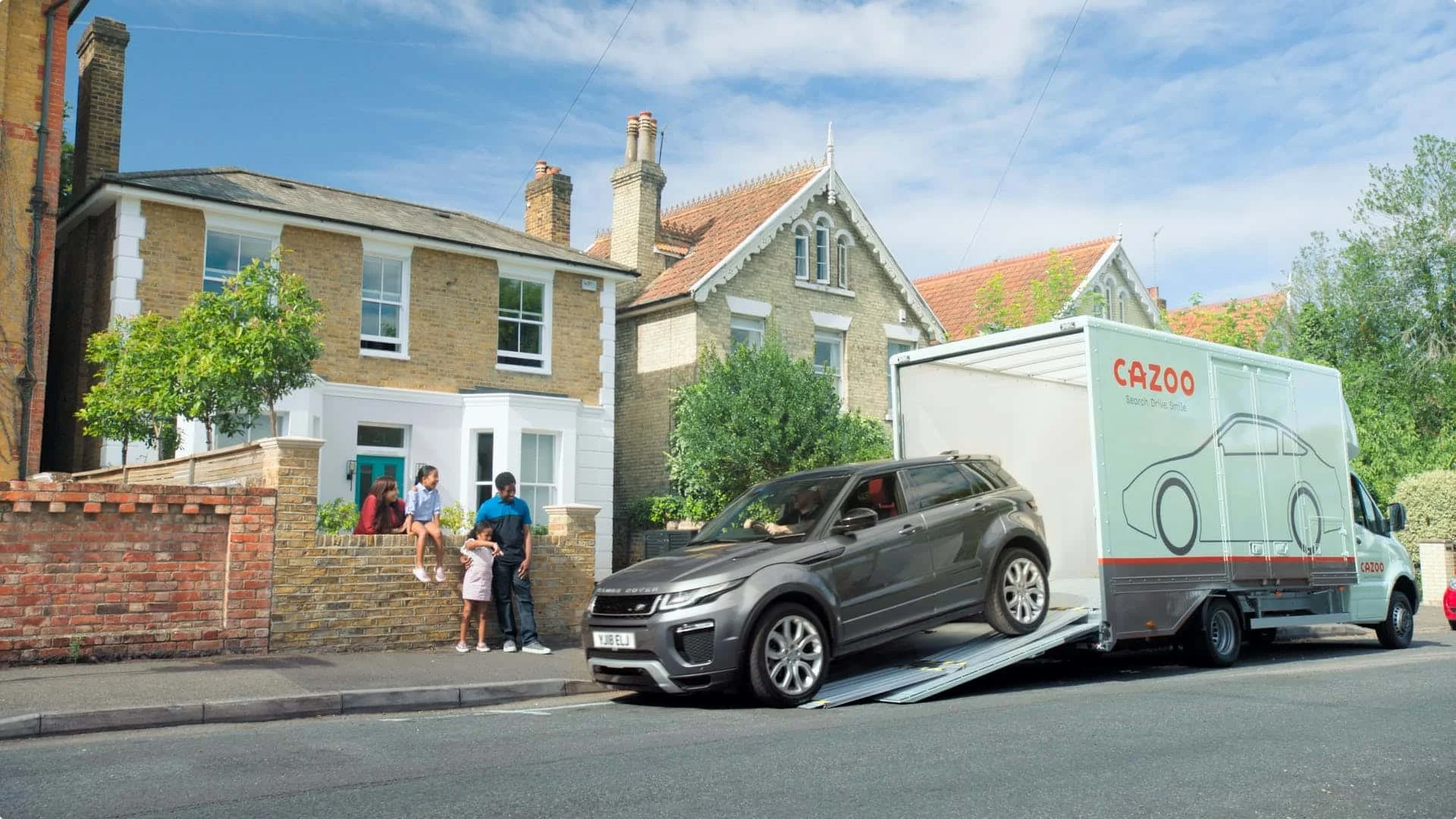 Learn about Cazoo's mission and key values. On this image you can see a Cazoo transporter delivering a car to a family.