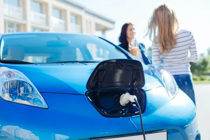 Blue electric car being charged
