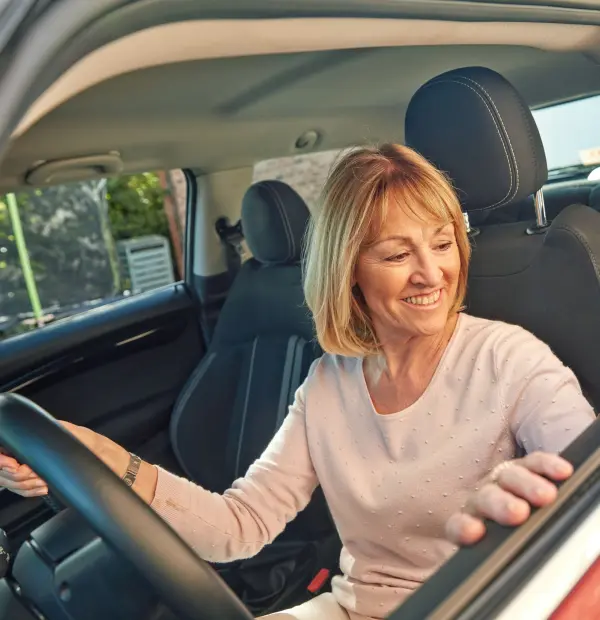 Dank kostenloser Easy-Start-Versicherung kannst du dein Auto sorgenfrei probefahren und kennenlernen. Auf dem Bild zu sehen ist eine Kundin, die in ihrem Cazoo Auto sitzt. 