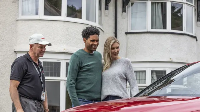 Happy couple looking at their new car from Cazoo