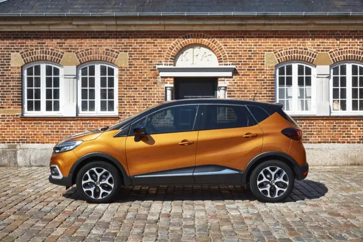 The side exterior of a yellow Renault Captur