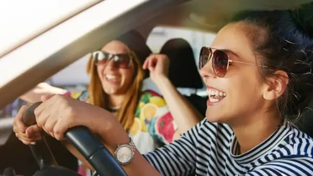 Frauen im Auto lachend - 8 Tipps für den Kauf deines ersten Autos