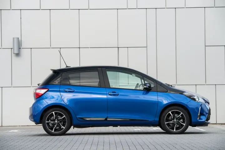 The side exterior of a blue Toyota Yaris