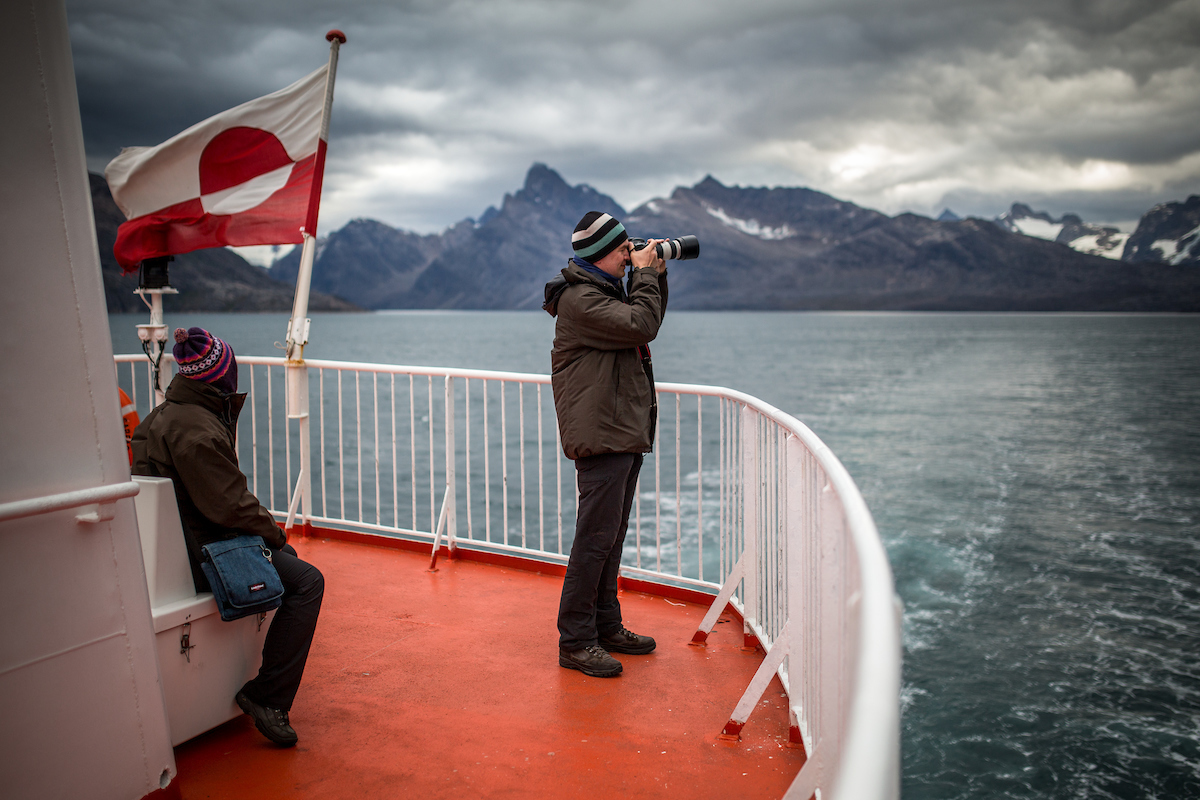 A photographer on the upper deck of Sarfaq Ittuk in Greenland