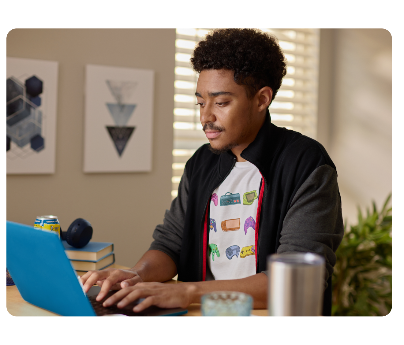 A young man looking at a long receipt at his home desk.