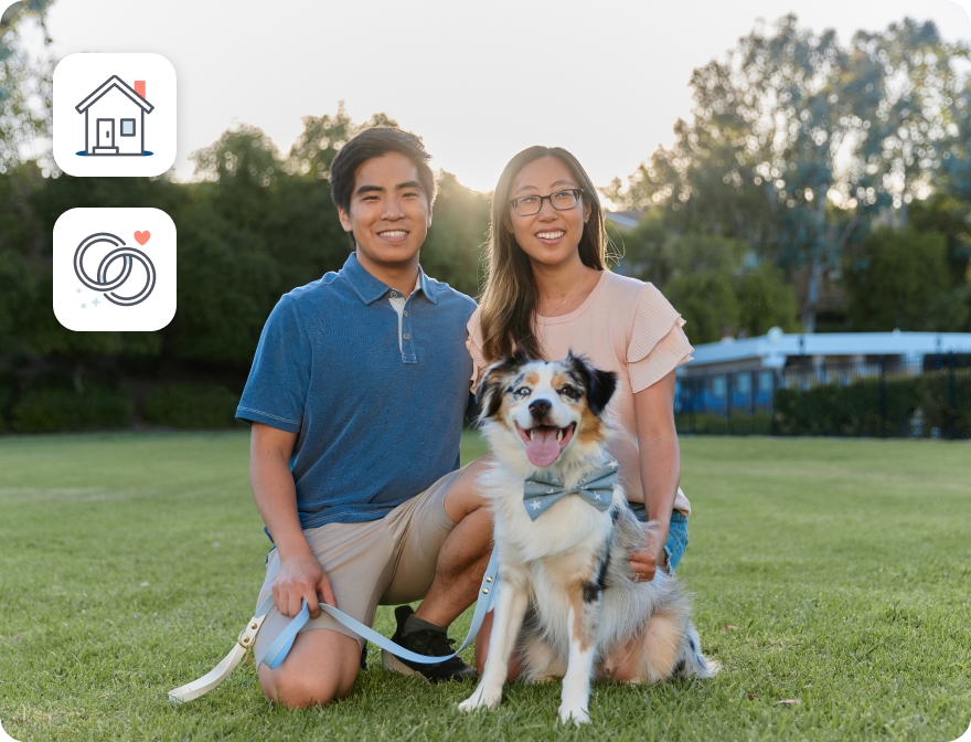 A young couple of Asian background smiling broadly with their dog in the park. Two illustrations in the background of a house and wedding bands.