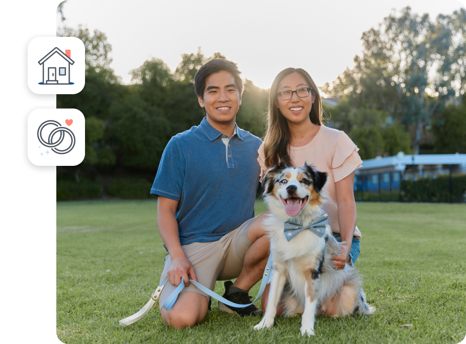 A young couple of Asian background smiling broadly with their dog in the park. Two illustrations in the background of a house and wedding bands.
