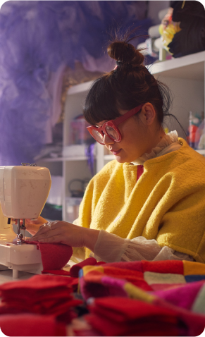 Une styliste élégante travaille avec des tissus sur une machine à coudre dans son studio.