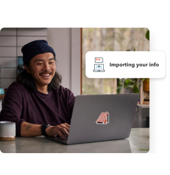 A young man smiling while working on his laptop in his home setting. Secondary illustration with “Importing your info” text and laptop icon.