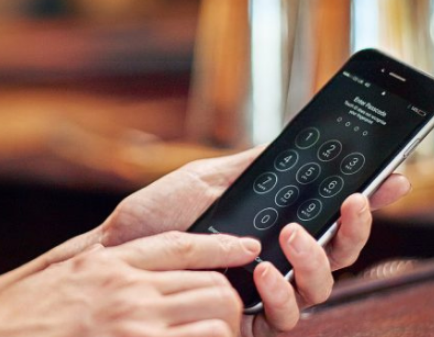   Bartender holding a mobile phone in a bar setting 