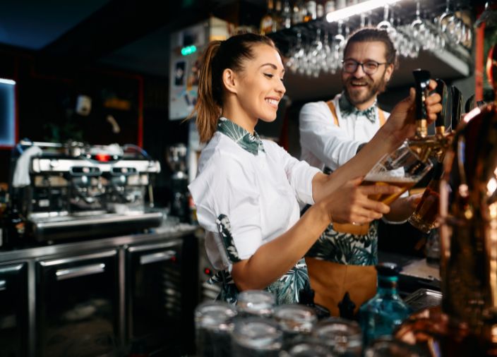 Bar multiestación con dos bartenders sonriendo