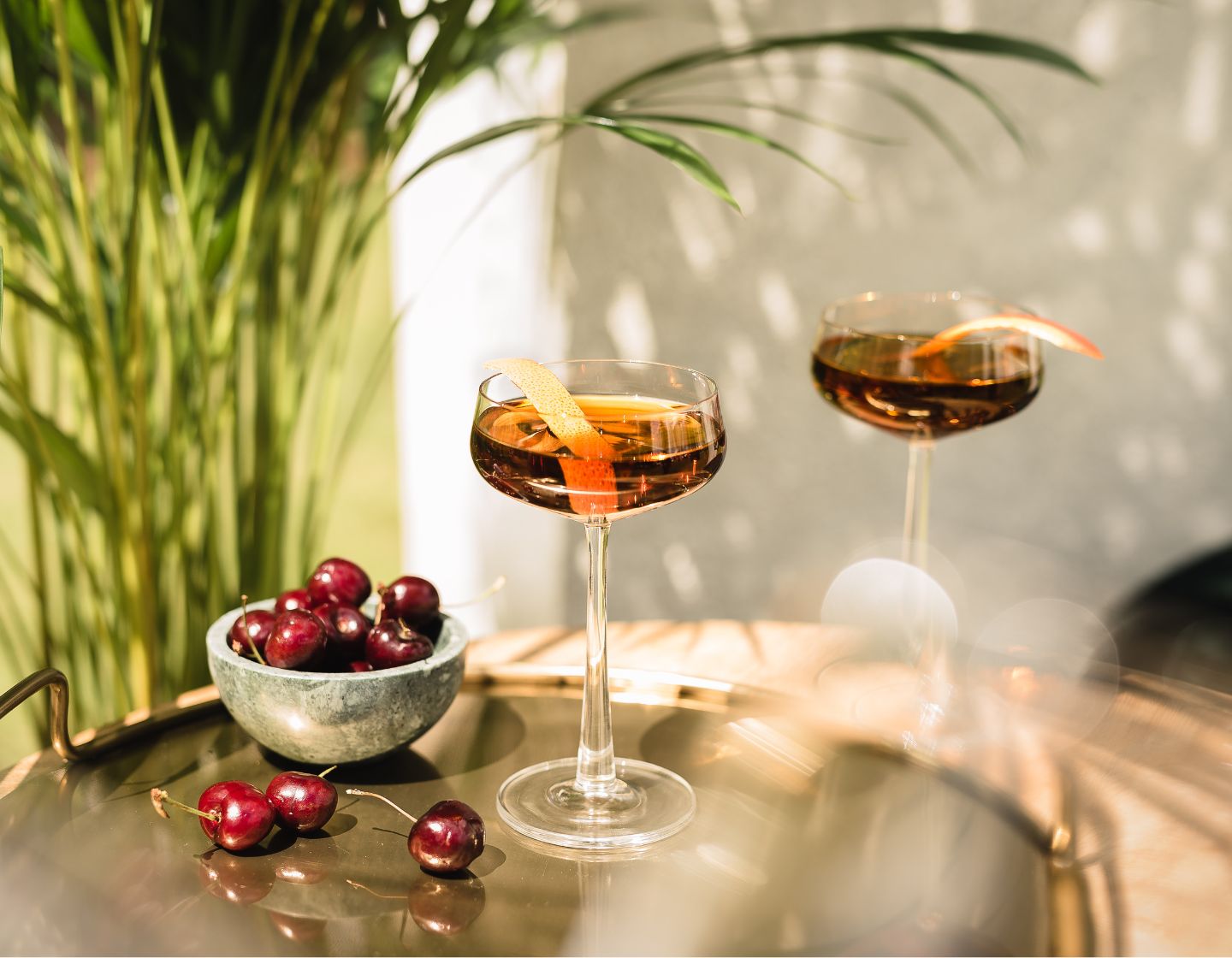 Zacapa-Flasche auf dem Tisch, daneben Cocktail und Kirschen