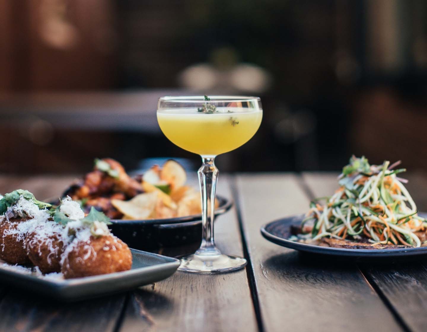 Cocktail Martini with small plates of food on table