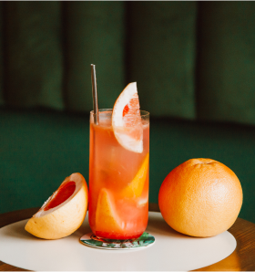 Grapefruit flavoured cocktail garnished with a wedge of gapefruit