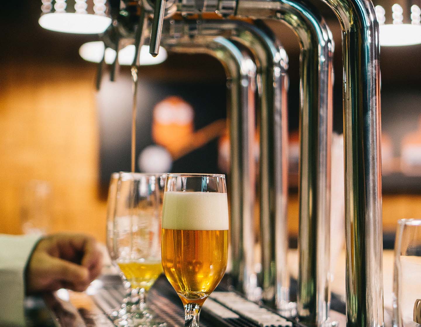 A pint being poured from a tap in a bar 
