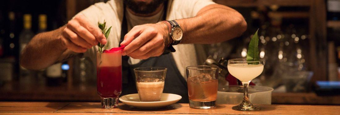 Bartender dándole los toques finales a un cóctel