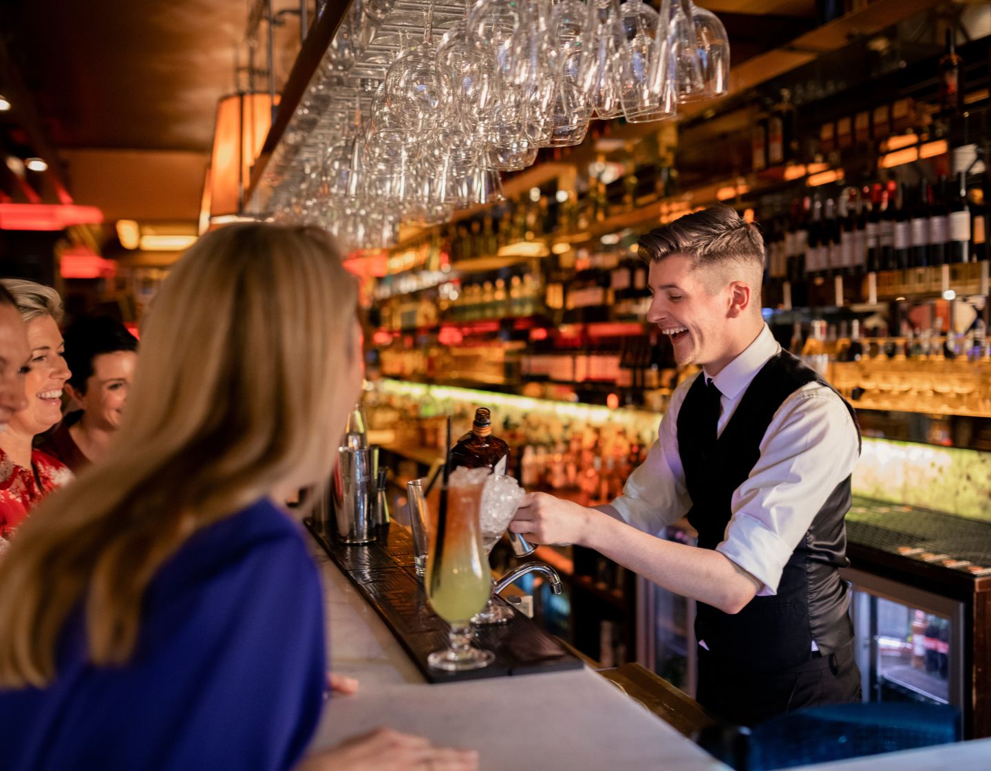 El personal del bar interactúa con los clientes y éstos reaccionan positivamente