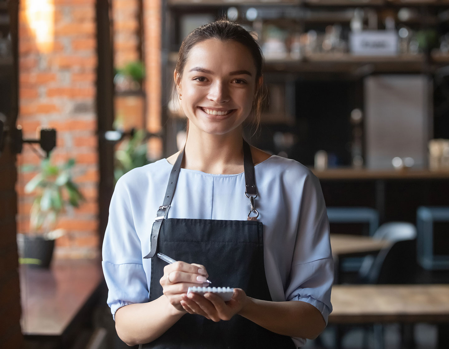 Smiling server with order notebook
