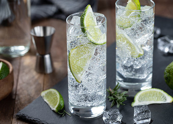 Dos vasos altos de ginebra con tónica, con hielo y rodajas de lima