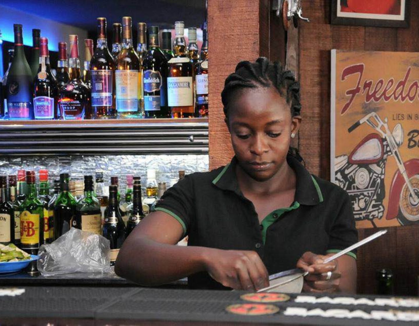Barman coando gelo atrás do bar
