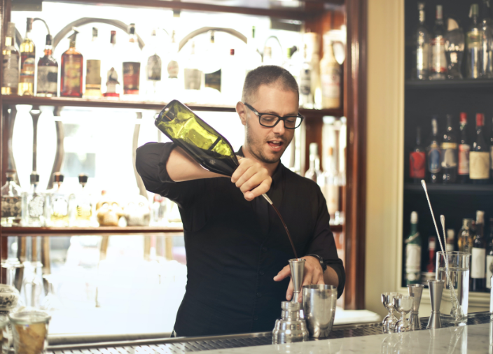 Bartender using speed pourer to pour liquid into jigger 