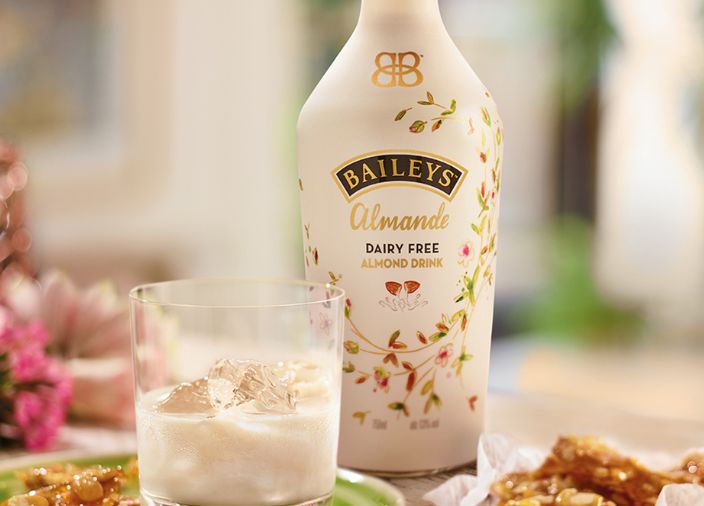 Una botella de Baileys Almande, con un Baileys sin lactosa servido en un vaso con hielo