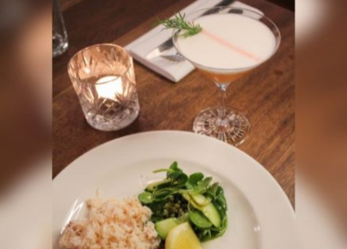 Plate of food with cocktail and candle