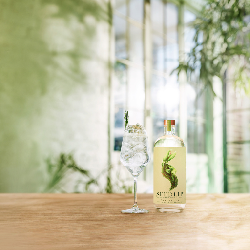 Botella de Seedlip Garden 108 en la mesa junto al cóctel 
