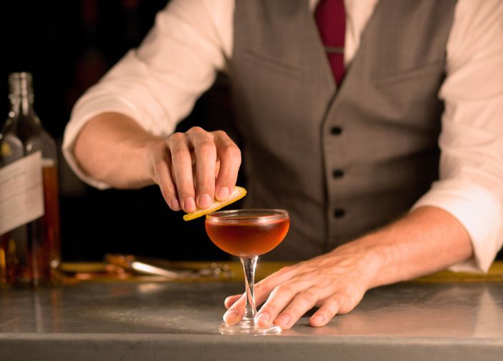 Coquetel premium sendo preparado por um bartender.