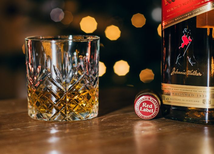 Glass of Johnnie Walker Red Label in a whisky glass beside bottle of Johnnie Walker Red Label    