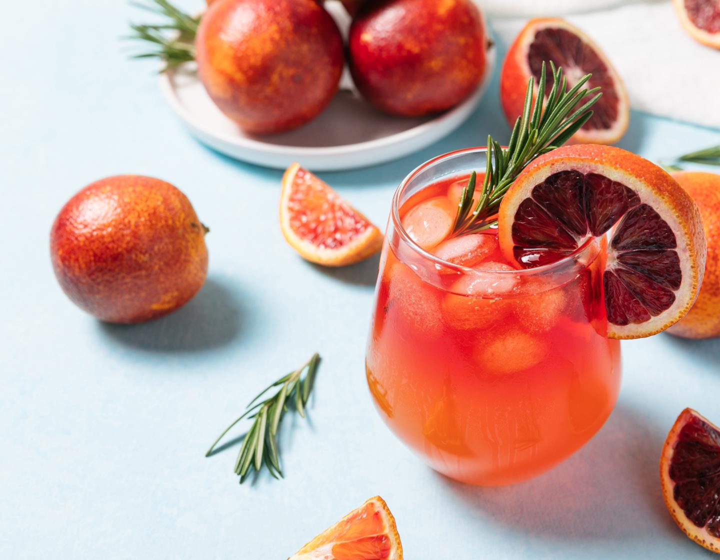 Ein Cocktail auf einem Tisch mit Obstgarnitur