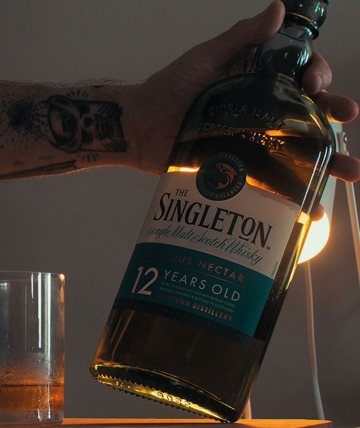 Hombre sosteniendo una botella de whisky The Singleton 12 year old
