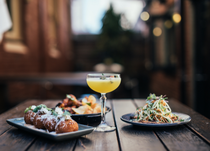 Cocktail and plates of food on table