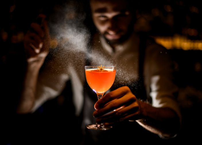 bartender spraying cocktail with scent