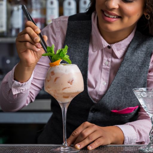 Barman adicionando um enfeite de folhas a um coquetel
