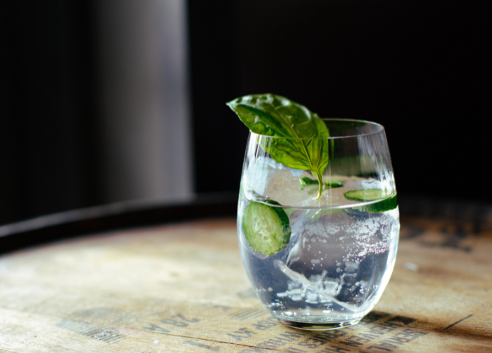 Gin tonic servido en copa de ginebra con hielo y garnish 