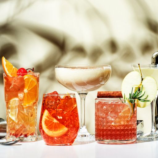   Rum cocktails on table with bar tools behind 