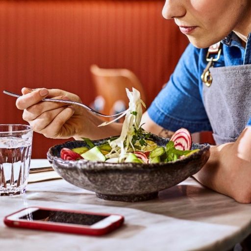 Woman eating a salad and having a break from a busy shift working in a restaurant or bar
