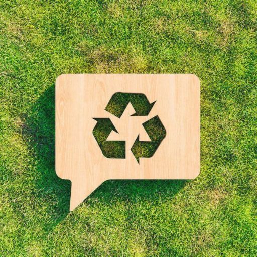 Cartel de reciclaje de madera sobre pasto verde