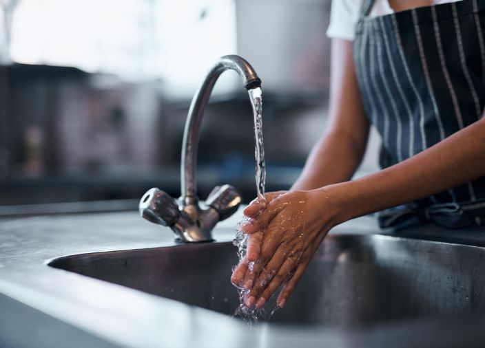 Washing hands under a running tap