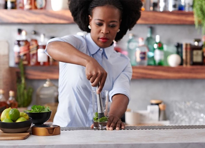 Una mujer usando un triturador en la cocina.