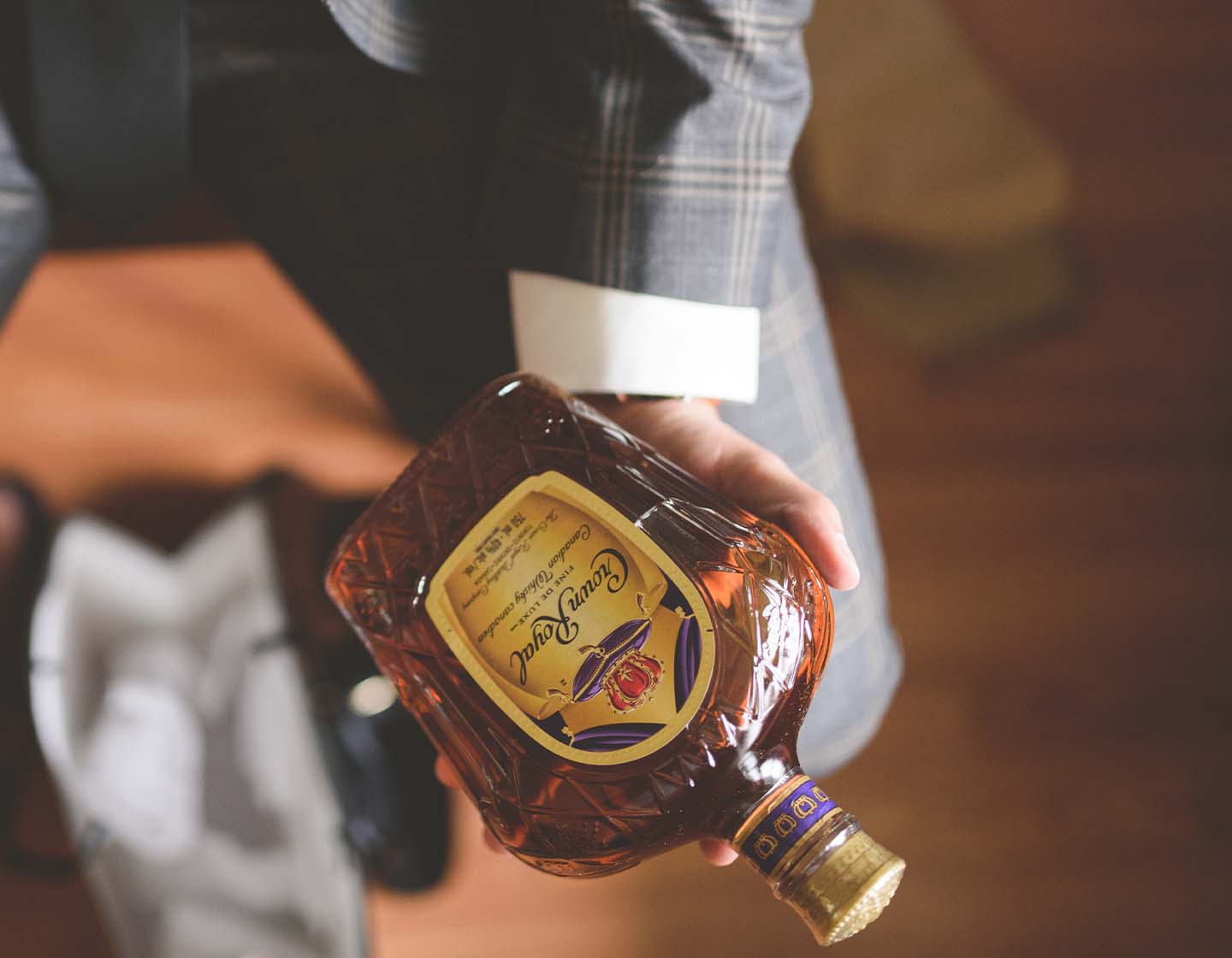 Mano sosteniendo una botella de Crown Royal