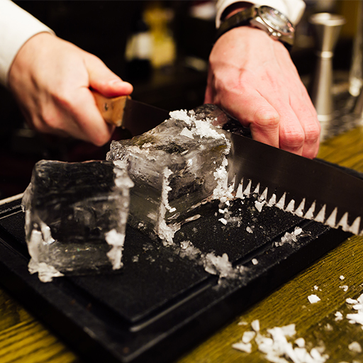 Losa grande de hielo cortada en tres trozos más pequeños por un profesional con un cuchillo específico.