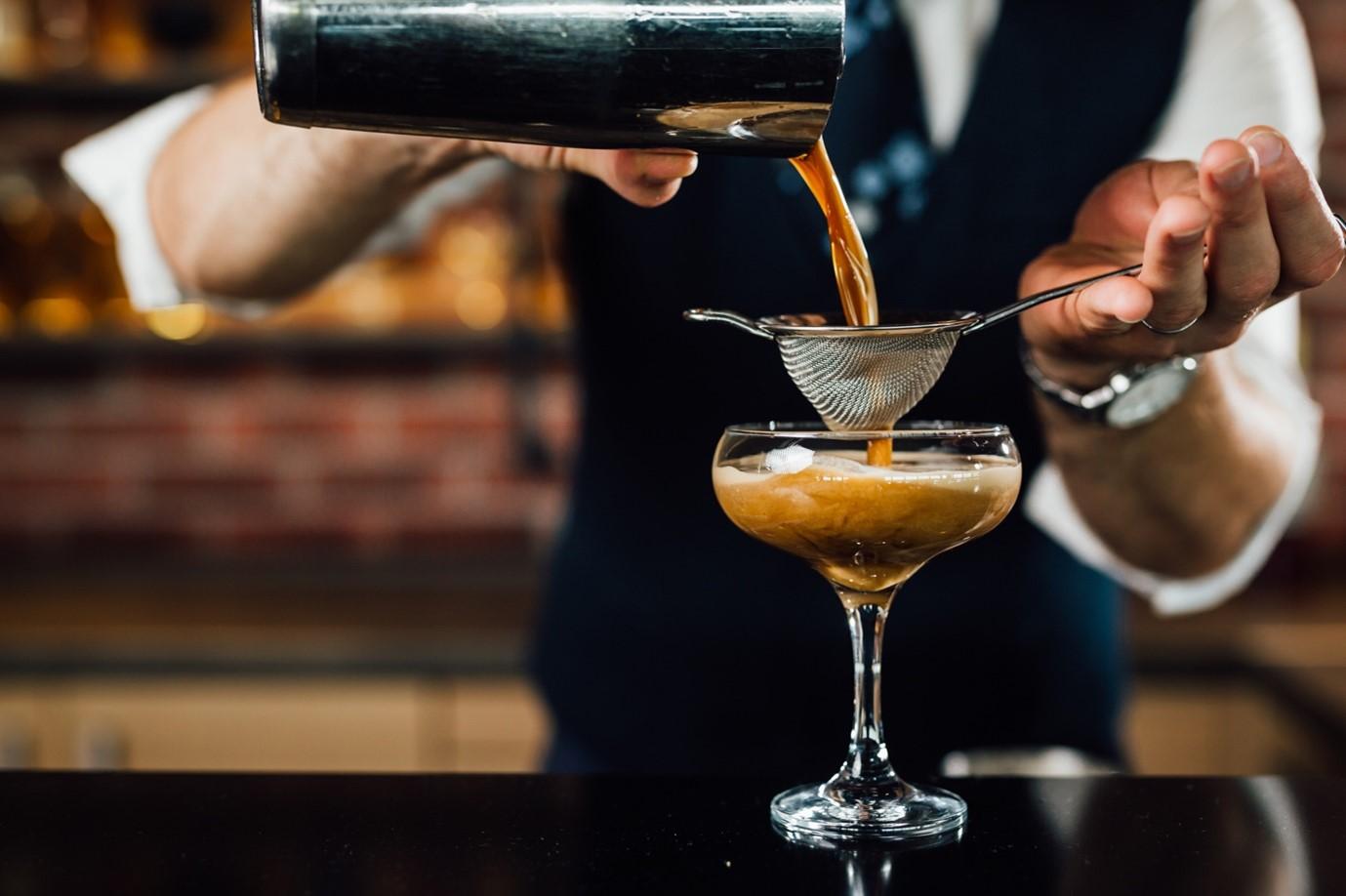 Ein Barkeeper mixt einen Cocktail mit Kaffee